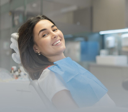 Young man in dental chair admiring his smile in yellow mirror